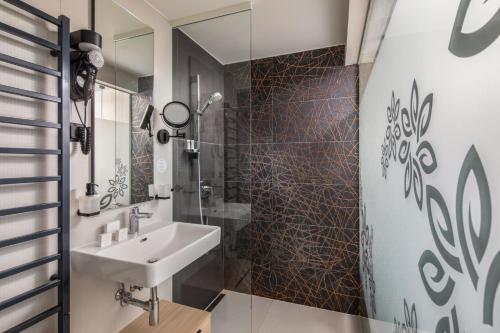 a bathroom with a sink and a shower at Sungarden Wellness Hotel Siófok in Siófok
