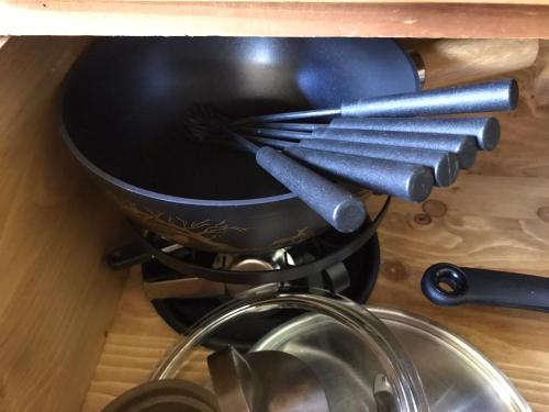 a black pot on top of a stove with utensils at Mountain River Luxury Apartment in Val dʼIlliez