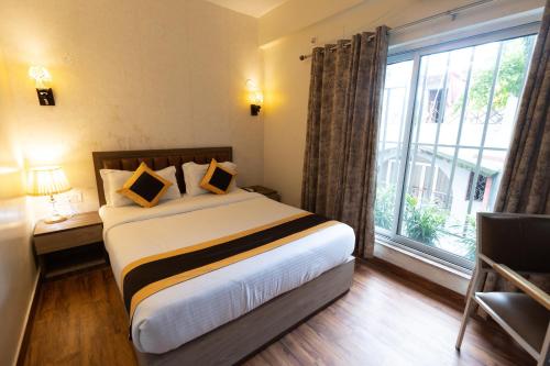 a hotel room with a bed and a large window at The Lake Palm Hotel in Kolkata