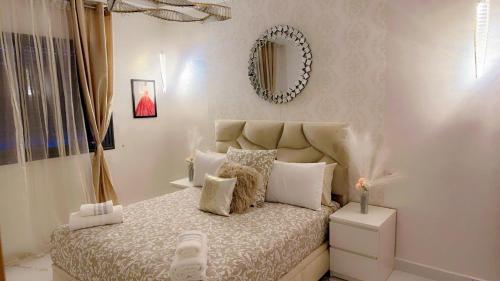 a bedroom with a bed and a mirror on the wall at Superbe appartement de luxe- proche de la mer - Dahomey city - Bouznika in Bouznika