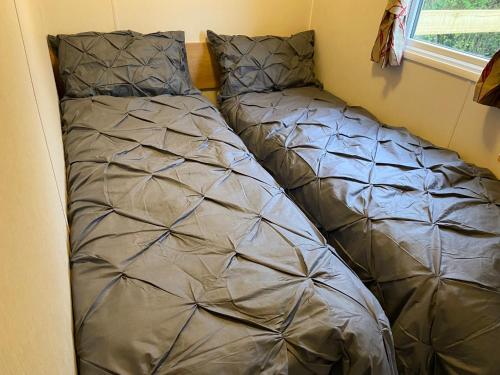 two beds in a corner of a room at Red Lion Holiday Home 1 in Lincolnshire