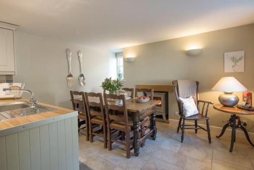 une cuisine et une salle à manger avec une table et des chaises dans l'établissement Duck Cottage Milldale Alstonefield Peak District, à Alstonfield