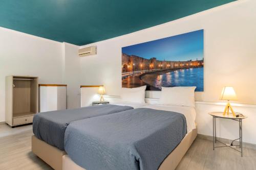 a bedroom with a bed and a painting on the wall at Lefka Hotel & Apartments in Rhodes Town