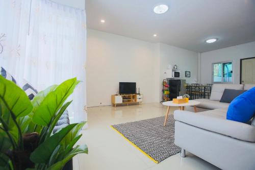 a living room with a couch and a tv at Trisisters Home by Greenway night market in Hat Yai