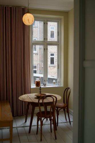 a dining room with a table and a window at SJ Apartment in Aarhus