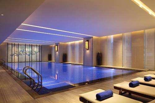 a swimming pool with blue lighting in a building at Wanda Realm Guangyuan in Guangyuan