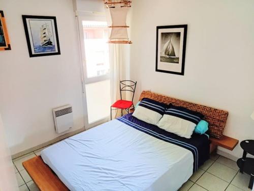 une chambre avec un lit et une chaise rouge dans l'établissement Appartement F2 41m2, à Saint Cyprien Plage