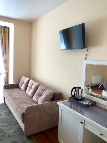 a living room with a couch and a tv on the wall at Helen Hotel in Mykolaiv