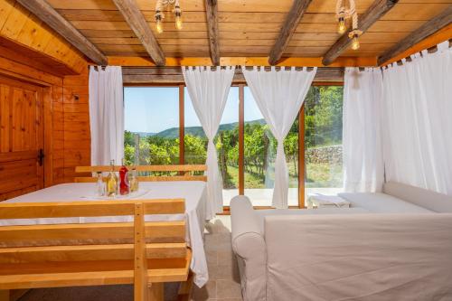 Un dormitorio con dos camas y una gran ventana. en Wine Garden House, en Grižane