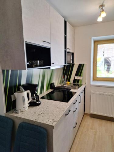 a kitchen with white cabinets and a counter top at ALPSKA ROŽA in Kranjska Gora