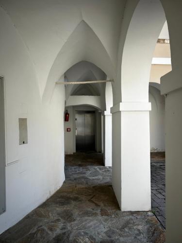 an empty hallway with white walls and a pillar at Schloss Apartment Lankowitz in Maria Lankowitz
