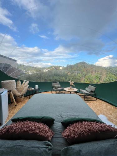 a bedroom with a large bed and a large window at Entre Ciel et Rivière in Bouillon