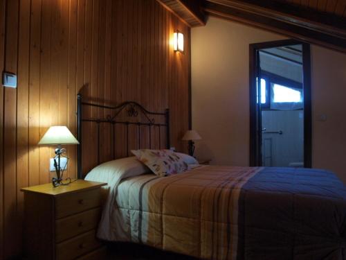 ein Schlafzimmer mit einem Bett und einem Tisch mit einer Lampe in der Unterkunft Casa Notario in Asín de Broto