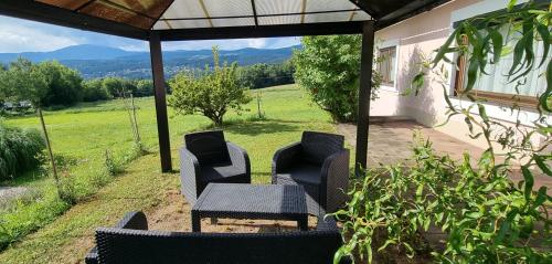 a patio with chairs and a table with a view at Bungalow & Apartments "Am Deber" Velden - Augsdorf in Velden am Wörthersee
