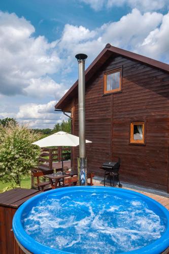 a large blue swimming pool in front of a house at ZACISZE Domek na Kaszubach Brodnica Dolna z balią z jacuzzi na wyłączność w cenie in Brodnica Dolna