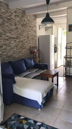 un salon avec un canapé bleu et une table dans l'établissement Casa Serena avec accès direct mer, jardin et barbecue, à Poggio-Mezzana