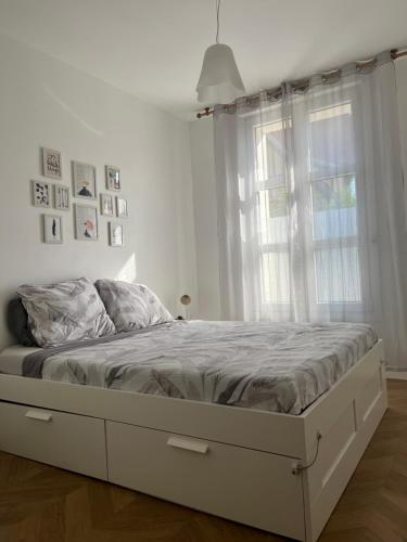 a white bed in a bedroom with a window at Appartement moderne et cosy , 5 min de la gare de RER D , remise des clés en main propre in Alfortville
