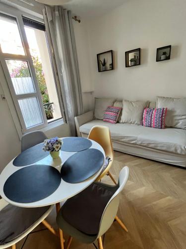 un salon avec une table, des chaises et un canapé dans l'établissement Appartement moderne et cosy , 5 min de la gare de RER D , remise des clés en main propre, à Alfortville