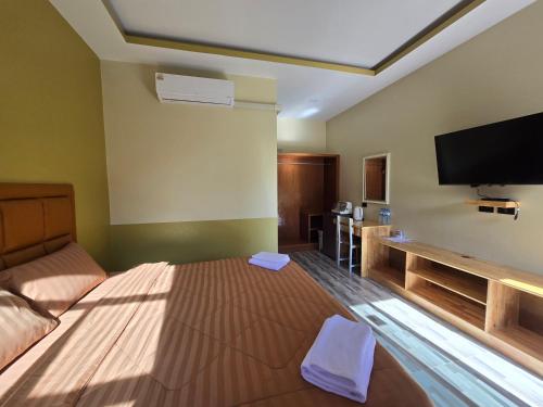 a hotel room with a bed and a flat screen tv at Khumkatang Resort & Restaurant in Ban Bang Rong