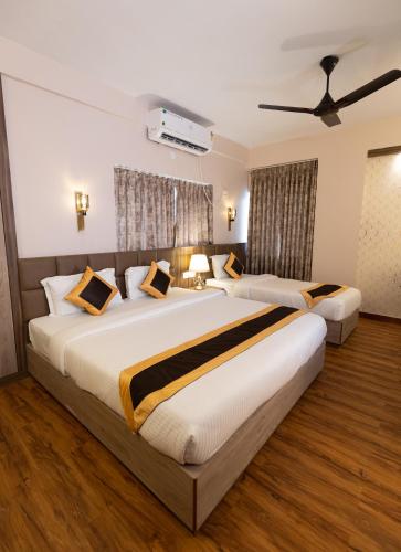 a hotel room with two beds in a room at The Lake Palm Hotel in Kolkata