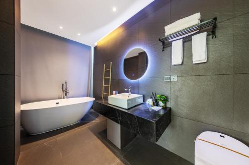 a bathroom with a white tub and a sink at XMAN Sunrise Peaks Resort--Free Pick-up in Zhangjiajie
