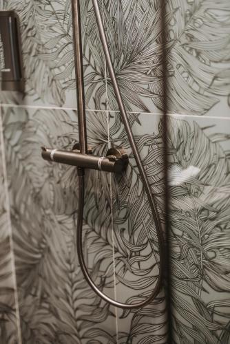 a shower hose is hooked up to a wall at Stari Toranj V studio apartman in Vukovar