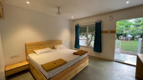 a bedroom with a bed and a large window at pra tiksha farm in Karjat