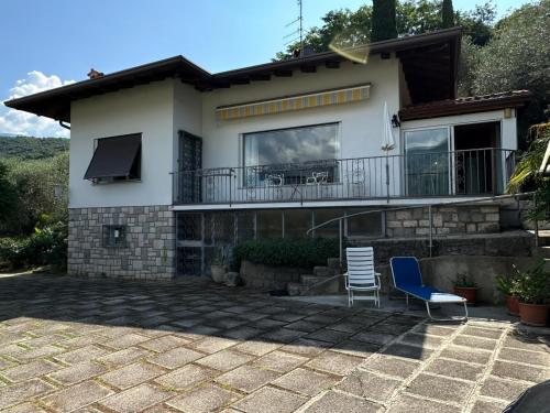 a house with a balcony and a blue chair at The Queen of Garda in Riva del Garda