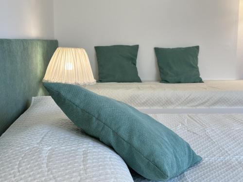 a bed with a blue pillow and a lamp on it at The Queen of Garda in Riva del Garda