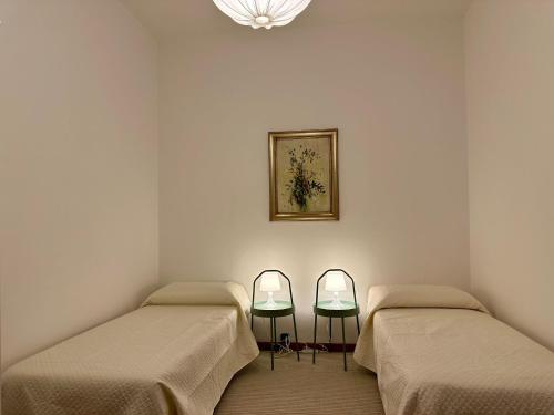 a room with two beds and a picture on the wall at The Queen of Garda in Riva del Garda