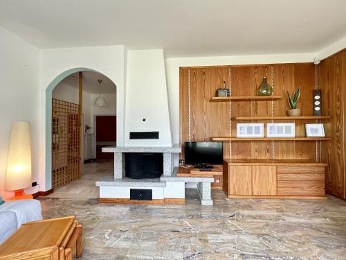 a living room with a fireplace and a tv at The Queen of Garda in Riva del Garda
