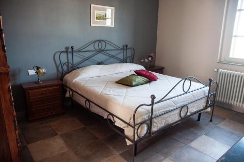 Bett mit Metallrahmen in einem Schlafzimmer in der Unterkunft Gemma B&B in Paderna
