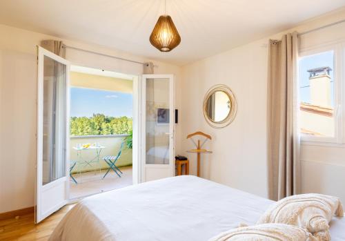 - une chambre avec un lit blanc et un balcon dans l'établissement Maison avec piscine à la campagne, à Saint-Géry
