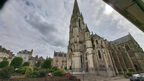 an old church with a steeple in front of it at Studio-centre ville in Châteaubriant