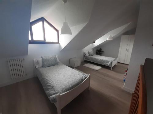 Cette chambre mansardée comprend un lit et une fenêtre. dans l'établissement Casa completa Loredo Beach, à Loredo