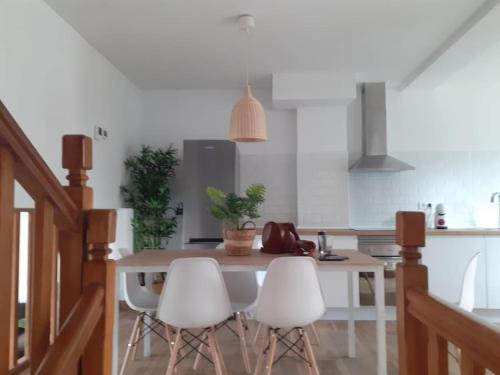 une cuisine avec une table et quatre chaises blanches dans l'établissement Casa completa Loredo Beach, à Loredo