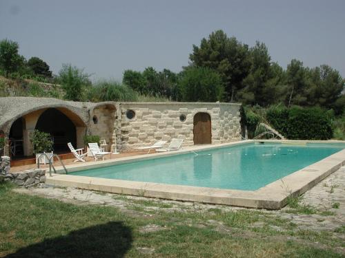une piscine devant un bâtiment en pierre dans l'établissement Logement Provence dans domaine oléicole, à Aubagne
