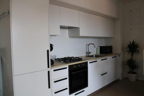a kitchen with white cabinets and a stove top oven at Bubi Apartments-Private parking in Zagreb