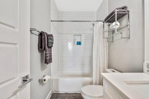 a white bathroom with a toilet and a sink at Luxury Living Superior Home in Prime Tampa Location in Tampa