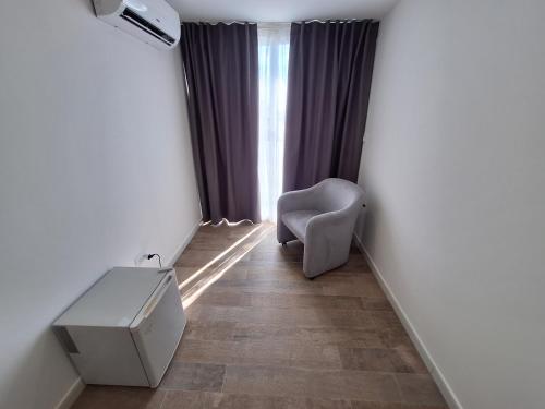 a room with a chair and a desk and a window at Domus Levante in Terrasini