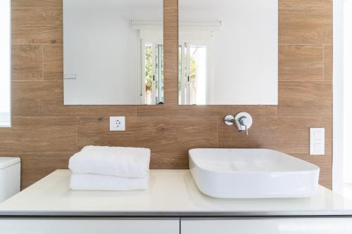 a bathroom with a white sink and a mirror at TrendyHomes Los Cinco Arcos in Níjar
