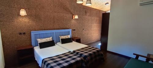 a bedroom with a bed with two pillows on it at Rilhadas Casas de Campo in Fafe