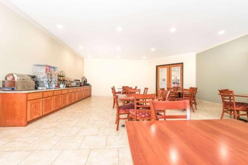 a restaurant with wooden tables and chairs and a counter at Ramada by Wyndham College Station in College Station