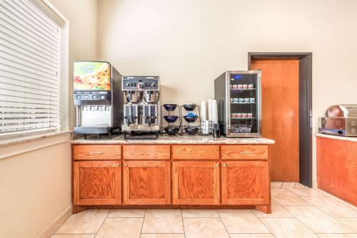 a kitchen with a counter with several coffee machines at Ramada by Wyndham College Station in College Station
