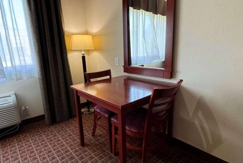 a room with a table and chairs and a mirror at Ramada by Wyndham College Station in College Station
