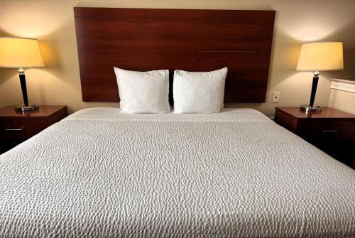 a bedroom with a large bed with two lamps at Ramada by Wyndham College Station in College Station
