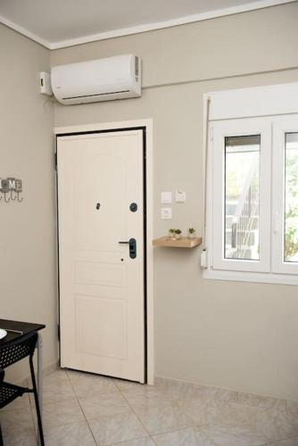 a white door in a room with a window at Iris apartment by the sea in Epanomi