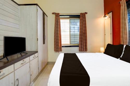 a bedroom with a bed and a flat screen tv at Hotel O Varun Residency in Bengaluru