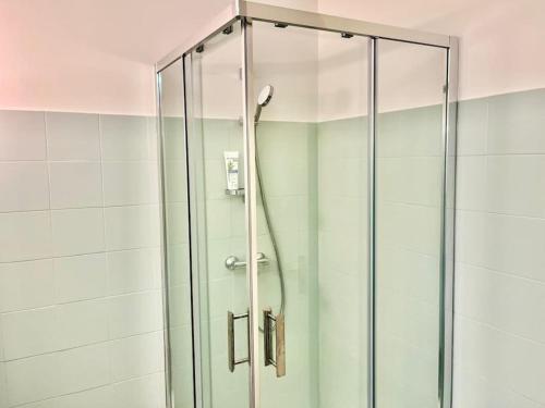 une douche avec une porte vitrée dans une salle de bain dans l'établissement Les Masters YourHostHelper, à Mandelieu-la-Napoule