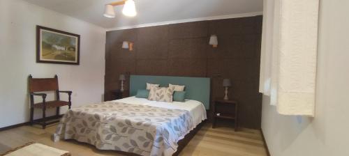 a bedroom with a bed and a chair in it at Rilhadas Casas de Campo in Fafe